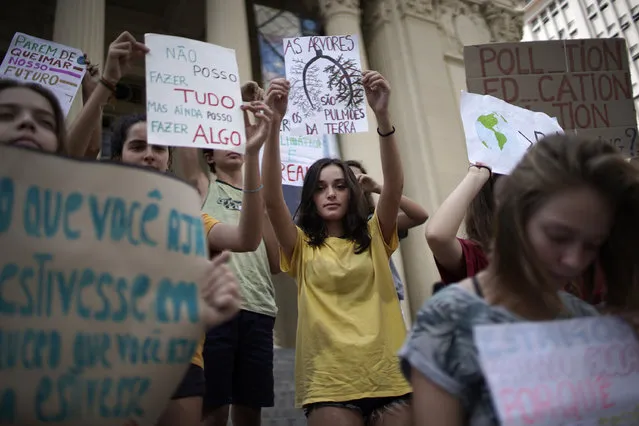 Students protest President Jair Bolsonaro's environmental policies in front the state legislature in Rio de Janeiro, Brazil, Friday, May 24, 2019. A small group of students gathered outside the state legislature to deliver a letter dated from the future in which they lamented Brazil's loss of coastline, rainforests and species. (Photo by Silvia Izquierdo/AP Photo)