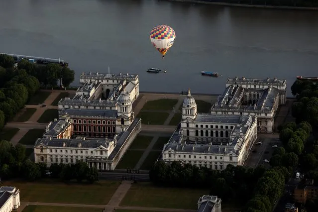 A hot air balloon flies over Greenwich Maritime Museum during the Lord Mayor's Hot Air Balloon Regatta, in London, June 9, 2019. (Photo by Simon Dawson/Reuters)