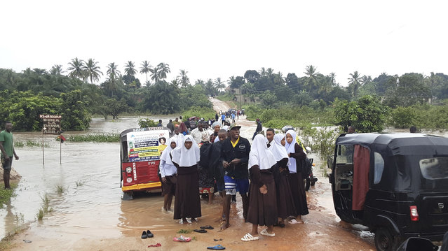 Schoolchildren stranded on a damaged River Zingiziwa bridge in Dar Esalaam, Tanzania Thursday, April 25, 2024. Flooding in Tanzania caused by weeks of heavy rain has killed 155 people and affected more than 200,000 others, the prime minister said Thursday. (Photo by AP Photo)