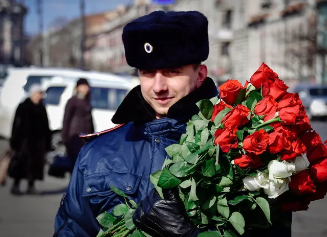 A traffic policeman gives flowers to female drivers ahead of International Women's Day on the citys Central Sqare in Vladivostok, Russia on March 7, 2017. (Photo by Yuri Smityuk/TASS via Getty Images)