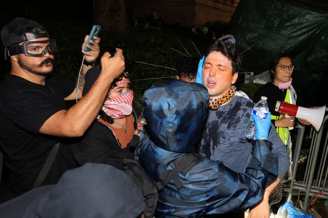 A pro-Palestinian protester gets help getting pepper spray rinsed off amid clashes with counter-protesters, at an encampment on the University of California, Los Angeles (UCLA) campus, amid the ongoing conflict between Israel and the Palestinian Islamist group Hamas, in Los Angeles, California, U.S., May 1, 2024. (Photo by David Swanson/Reuters)