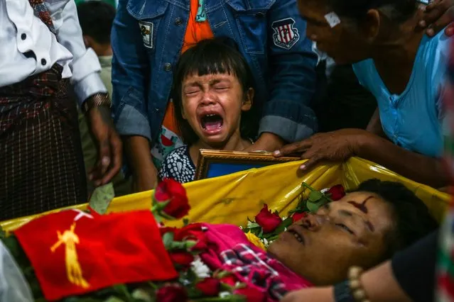 The daughter of Zwee Htet Soe, a protester who died during a demonstration against the military coup on March 3, cries during her father's funeral in Yangon on March 5, 2021. (Photo by AFP Photo/Stringer)