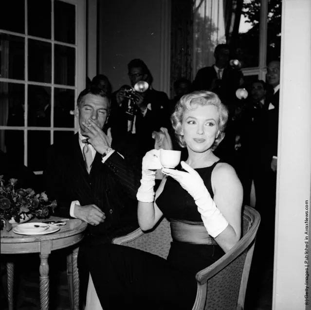 1956: American film star Marilyn Monroe (1926 - 1962) sits next to British thespian Laurence Olivier (1907 - 1989) at a press conference at the Savoy Hotel, London