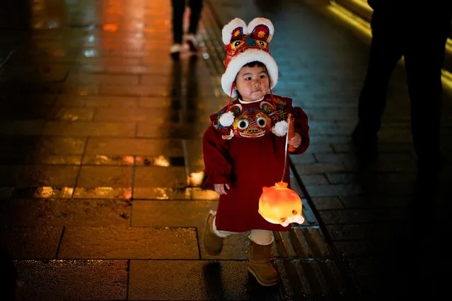 A child in a tiger costume walks with a lantern ahead of the Chinese Lunar New Year festivity at Yu Garden, following the new coronavirus disease (COVID-19) cases in Shanghai, China, January 28, 2022. (Photo by Aly Song/Reuters)