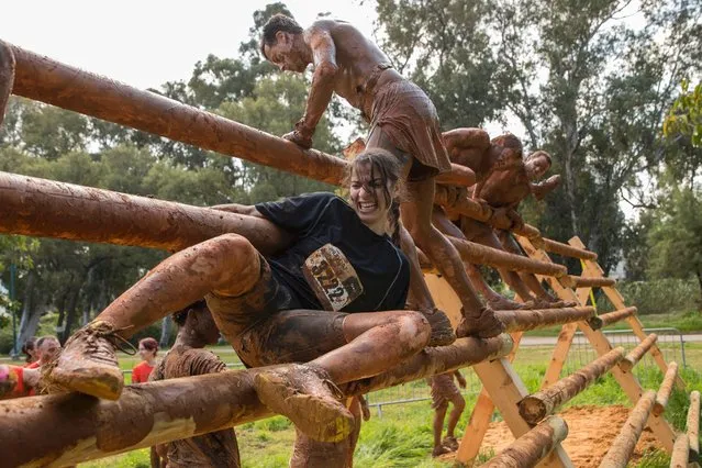 Participants take part in the Mud Day race, a 13km obstacle course, on March 24, 2017 in the Israeli Mediterranean coastal city of Tel Aviv. (Photo by Jack Guez/AFP Photo)