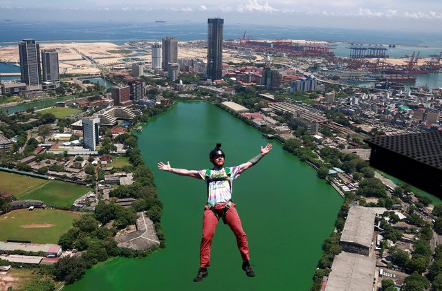 A base jumper leaps off the Lotus Tower, a 351.5 m tall tower in Colombo, Sri Lanka on May 13, 2024. (Photo by Dinuka Liyanawatte/Reuters)