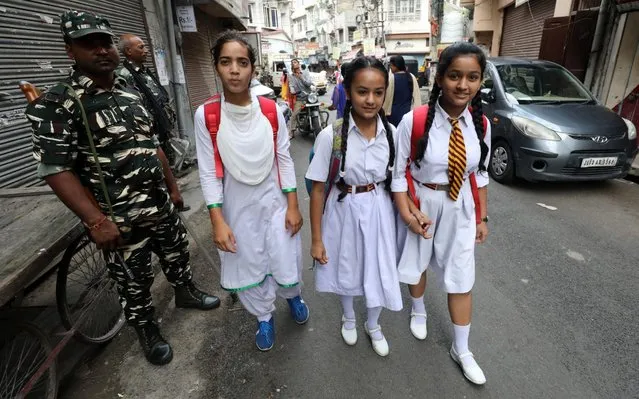 Indian paramilitary soldiers stand guard as children walk past on their way to school in Jammu, the winter capital of Kashmir, India, 10 August 2019. According to the order issued by Jammu District Magistrate, all schools, colleges and academic institutions have resumed their functioning normally in Jammu. India has revoked the disputed Muslim majority region's special status, making a centrally-ruled union territory. Since the announcement of the repeal of Article 370 on 05 August, the Indian-administered Kashmir region has been under heavy lockdown with a restriction on public gatherings. Kashmir has been a disputed region since 1947 when India and Pakistan won their freedom from British rule. (Photo by Jaipal Singh/EPA/EFE/Rex Features/Shutterstock)
