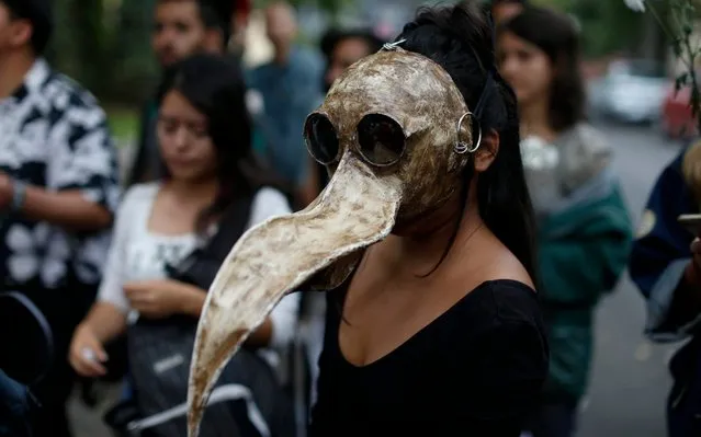 Medical student and environmentalist Sofia Guzman, 22, wears a mask she made to represent a toucan skull, during a protest to call for action to protect the Amazon rainforest, outside Brazil's embassy in Mexico City, Friday, August 23, 2019. Under increasing international pressure to contain fires sweeping parts of the Amazon, Brazil's President Jair Bolsonaro on Friday authorized use of the military to battle the massive blazes. (Photo by Rebecca Blackwell/AP Photo)