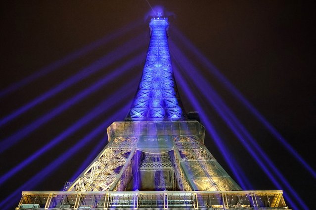 A photo shows the Eiffel Tower lit in the colours of the Ukrainnian flag in a show of support to Ukraine, one year after Russia launched a military invasion on the country, in Paris, on February 23, 2023. Kyiv is set on February 24 to mark the first anniversary of Moscow's invasion, as Ukrainians braced for possible new Russian strikes after a year of defiance and grief, as a year ago, Russia's President stunned the world by sending troops across the border in the early hours of the morning to “de-militarise” Ukraine, in a move seen as punishment for Kyiv's pivot to the West. (Photo by Ludovic Marin/AFP Photo)