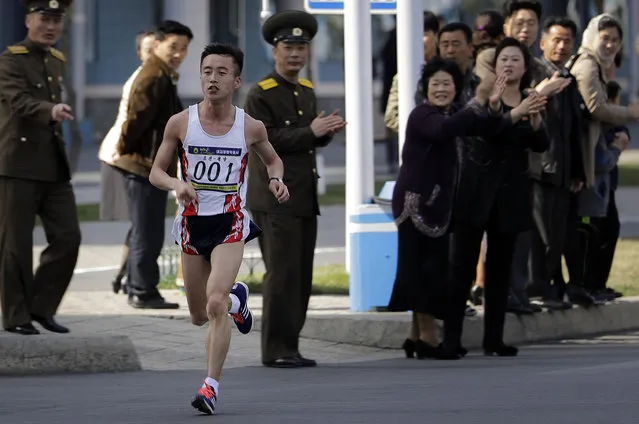Pak Chol of North Korea leads the Pyongyang marathon as supporters cheer for him from the side of the street on Sunday, April 9, 2017, in Pyongyang, North Korea. Hundreds of foreigners took to the streets of Pyongyang on Sunday for an annual marathon that has become one of the North Korean capital's most popular tourist events. (Photo by Wong Maye-E/AP Photo)
