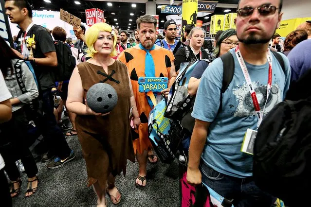 Sabastian and Julia Sanzberro, dressed as Fred Flinstone and Barney Rubble, walk the trade floor during Preview Night at the 2015 Comic-Con International in San Diego, California July 8, 2015. (Photo by Sandy Huffaker/Reuters)