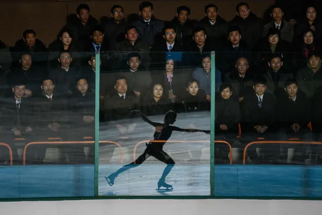 An ice skater is reflected in a glass panel as spectators attend the “26th Paektusan Prize Figure Skating Festival in Celebration of the Day of the Shining Star” as part of celebrations marking the birthday of late North Korean leader Kim Jong Il, in Pyongyang on February 15, 2019. (Photo by Ed Jones/AFP Photo)