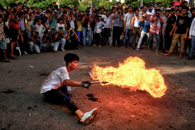 An Indian Shiite Muslim fire eater perform stunts on the occasion of Muharram during a procession at Kolkata. Muharram is the first month of the Islamic calendar & Ashura is the tenth day of the month of Muharram, on which the commemoration of the martyrdom of Imam Hussain, the grandson of Prophet Muhammad (PBUH), during the battle of Karbala, is done. It is part of Mourning for Shia Muslims and a day of fasting for Sunni Muslims that is observed all over the World. (Photo by Avishek Das/SOPA Images/LightRocket via Getty Images)