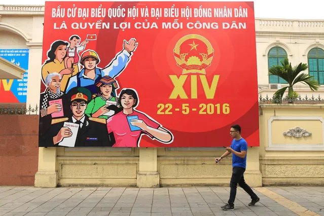 A man walks pass a billboard of Vietnam's Parliamentary Election in Hanoi, Vietnam on Sunday, May 22, 2016. Ahead of President Barack Obama's first visit to Vietnam, the country voted Sunday in once-every-five-year-elections for a rubber-stamp parliament whose membership has already been largely determined by the Communist Party. (Photo by Hau Dinh/AP Photo)