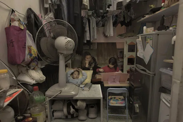 In this Friday, March 17, 2017 photo, Li Suet-wen and her son, 6, and daughter, 8, live in a 120-square foot room crammed with a bunk bed, small couch, fridge, washing machine and small table in an aging walkup in Hong Kong as she pays HK$4,500 ($580) a month in rent and utilities. That's nearly half the HK$10,000 ($1,290) she earns at a bakery decorating cakes. They're among an estimated 200,000 people in the former British colony living in “subdivided units”. That's 18 percent more than four years ago and includes 35,500 children 15 and under, government figures show. (Photo by Kin Cheung/AP Photo)