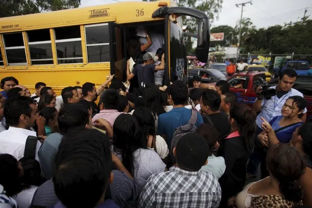 People try to board a goverment bus during the second day of a suspension of public transport services in Apopa, El Salvador July 28, 2015. (Photo by Jose Cabezas/Reuters)