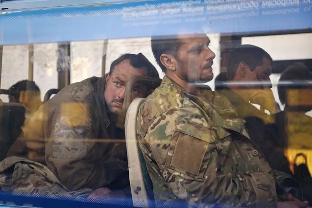 Ukrainian servicemen sit in a bus after they were evacuated from the besieged Mariupol's Azovstal steel plant, near a remand prison in Olyonivka, in territory under the government of the Donetsk People's Republic, eastern Ukraine, Tuesday, May 17, 2022. (Photo by Alexei Alexandrov/AP Photo)