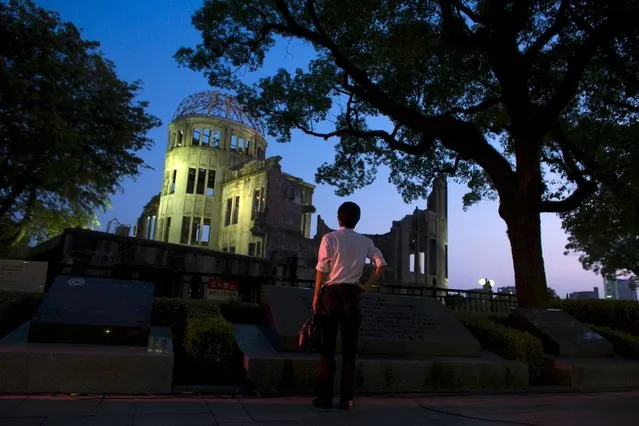 A man looks at the Atomic Bomb Dome before nightfall in Hiroshima, western Japan, August 5, 2015. Japan will mark on Thursday the 70th anniversary of the attack on Hiroshima, where the U.S. dropped an atomic bomb on August 6, 1945, killing about 140,000 by the end of the year in a city of 350,000 residents. It was the world's first nuclear attack. (Photo by Thomas Peter/Reuters)