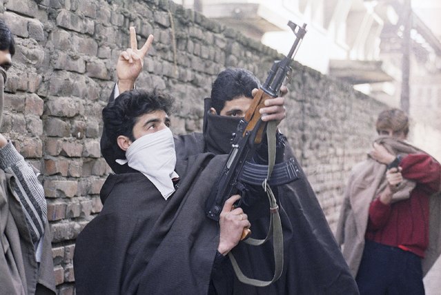 Young Muslim separatists come into the streets with guns, defying an army curfew and demanding independence in Kashmir, Monday, January 23, 1990. Kashmir is divided between India and Pakistan and claimed by both in its entirety. The region’s fury at Indian rule has been long seething and most Muslim Kashmiris support the rebel goal of uniting the territory, either under Pakistani rule or as an independent country. An armed rebellion against Indian rule began in 1990's. (Photo by Ajit Kumar/AP Photo/File)