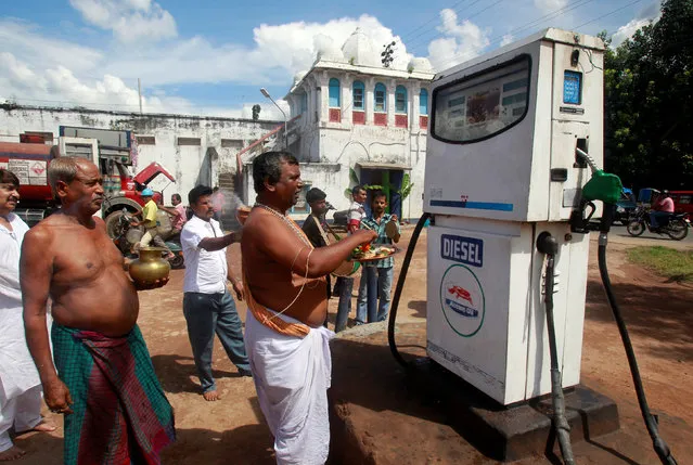 A Hindu priest does prayers for a diesel pump at a fuel station on the occasion of Vishwakarma Puja or the festival of the Hindu deity of architecture and machinery in the northeastern Indian city of Agartala September 17, 2013. (Photo by Jayanta Dey/Reuters)