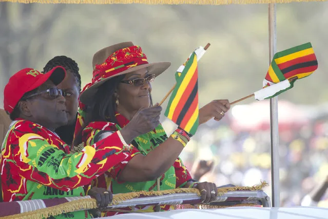 Zimbabwe President Robert Mugabe and his wife Grace wave the Zimbabwean flag while greeting supporters at a rally in Lupane about 170 Kilometres north of Bulawayo, Friday, July 21, 2017. Mugabe's rally is his first since his return from a routine medical review in Singapore. The world's oldest leader has launched a series of rallies targeting the youth ahead of Presidential elections set for 2018. (Photo by Tsvangirayi Mukwazhi/AP Photo)