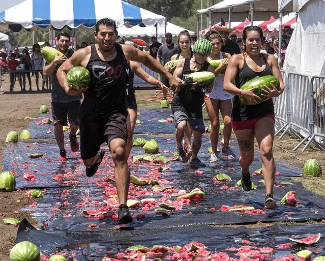 Festival-goers have gathered together to play homage to the humble watermelon during the 55th Annual Watermelon Festival on July 29, 2017. The fruit-themed festival is being held in Los Angeles, California and has been running for two days. The day has become a tradition because watermelons have long been the prized crop of the eastern San Fernando foothills. Not only are guests treated to free food, funfair rides and live entertainment, they can also enter themselves into melon-themed activities. (Photo by Xinhua News Agency/Rex Features/Shutterstock)