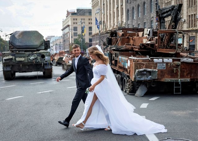 Newlyweds visit an exhibition displaying destroyed Russian military vehicles located on the main street Khreshchatyk as part of the upcoming celebration of the Independence Day of Ukraine, amid Russia's invasion, in central Kyiv, Ukraine on August 21, 2023. (Photo by Gleb Garanich/Reuters)