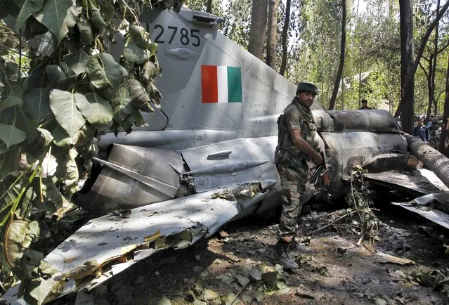 An Indian army soldier stands in front of the wreckage of a MiG-21 Bison aircraft of the Indian Air Force (IAF) after it crashed in Soibugh in Budgam district of Kashmir August 24, 2015. The pilot of the aircraft ejected safely, according to local media reports. (Photo by Danish Ismail/Reuters)