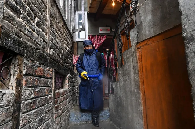 A municipal worker sanitises an alley of a residential area declared as a Red Zone for coronavirus by authorities during a government-imposed nationwide lockdown as a preventive measure against the COVID-19 coronavirus, in Srinagar on April 8, 2020. (Photo by Tauseef Mustafa/AFP Photo)