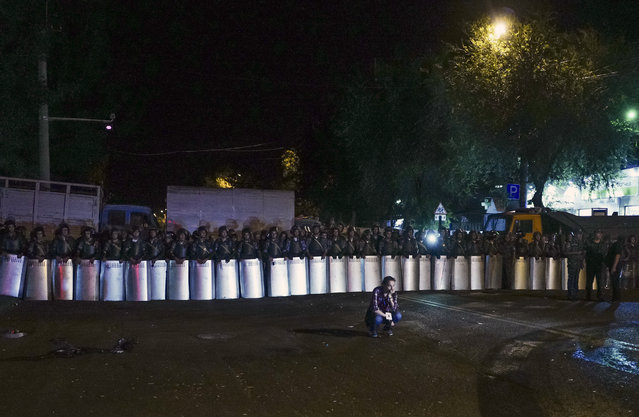 Riot police secure a police station, which is being held by an armed group, in Yerevan, Armenia, early Wednesday, July 27, 2016. (Photo by Vahan Stepanyan/PAN Photo via AP Photo)