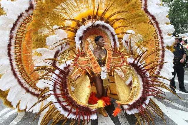 In this September 2, 2013, file photo, dressed in costume, Kelva Joseph makes her way along Eastern Parkway in the Brooklyn borough of New York during the West Indian Day Parade. The annual parade is set for Monday, September 1, 2014, in Brooklyn. It echoes traditional pre-Lenten Carnival festivities and features dancers wearing elaborate, often feathered costumes. (Photo by Tina Fineberg/AP Photo)