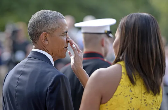 US First Lady Michelle Obama touches the nose of US President Barack Obama before he welcomes Singapore Prime Minister Lee Hsien Loong at the White House on August 2, 2016 in Washington, DC. (Photo by Brendan Smialowski/AFP Photo)