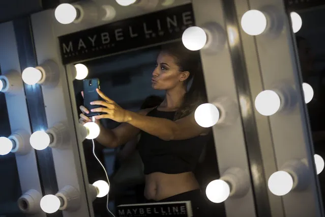 A model poses for a selfie snapshot at backstage before presenting designs during a MFS fashion show in Madrid, Spain, Monday, September 7, 2015. (Photo by Daniel Ochoa de Olza/AP Photo)