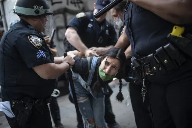 Police detain a protester during a solidarity rally for George Floyd, Saturday, May 30, 2020, in New York. Demonstrators took to the streets of New York City to protest the death of Floyd, a black man who was killed in police custody in Minneapolis on May 25. (Photo by Wong Maye-E/AP Photo)