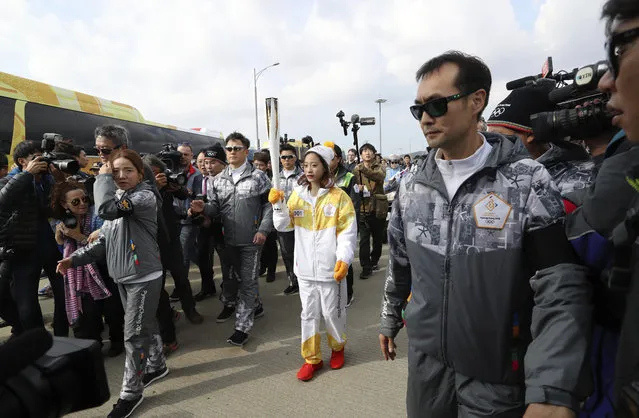 First torch bearer, South Korean figure skater You Young, center, carries an Olympic torch during the Olympic Torch Relay at Incheon Bridge in Incheon, South Korea, Wednesday, November 1, 2017. The Olympic flame arrived in South Korea on Wednesday where it will be passed throughout the country by thousands of torchbearers on a 100-day journey to the opening ceremony of the 2018 Winter Olympics in Pyeongchang. (Photo by Lee Jin-man/AP Photo)