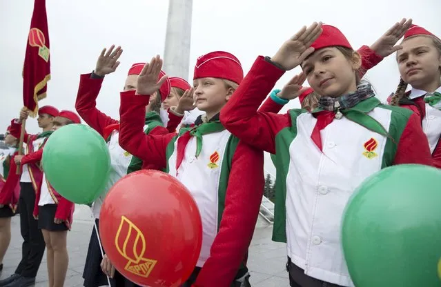 Belarusian schoolchildren salute during celebrations commemorating the 25th anniversary of the country's Young Pioneer movement in Minsk, September 13, 2015. Early pro-communist pioneer movements appeared in Russia after the 1917 Bolshevik revolution. In May 1922, they were organised into the Young Pioneer Organisation of the Soviet Union with units active in all republics of the union. (Photo by Vasily Fedosenko/Reuters)