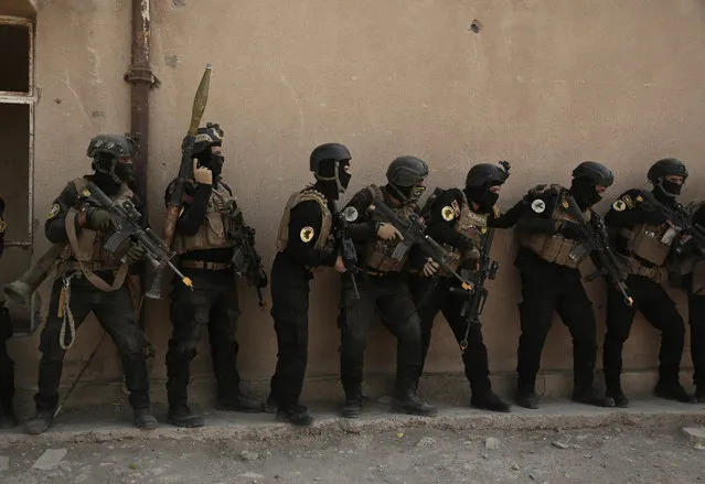In this Saturday, August 13, 2016 photo, soldiers from the 1st Battalion of the Iraqi Special Operations Forces are stacked against a building during a training exercise to prepare for the operation to re-take Mosul from Islamic State militants, in Baghdad, Iraq. Iraq's leaders have repeatedly promised that Mosul – which has been in the hands of IS militants for more than two years now – will be retaken this year. (Photo by Maya Alleruzzo/AP Photo)