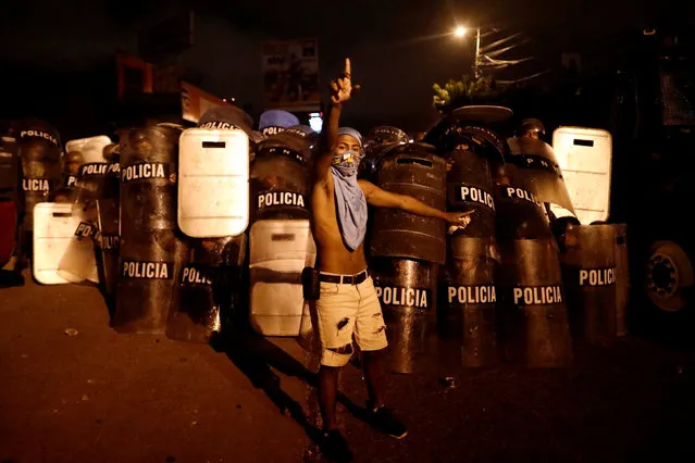 A supporter of Salvador Nasralla, presidential candidate for the Opposition Alliance Against the Dictatorship, gestures in front of riot police while he waits for official presidential election results outside the warehouse of the Supreme Electoral Tribunal in Tegucigalpa, Honduras, November 30, 2017. (Photo by Edgard Garrido/Reuters)