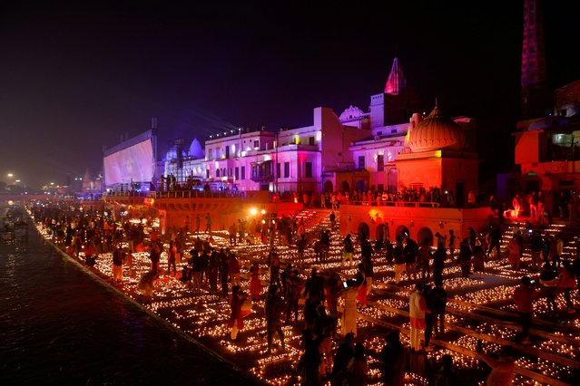 Hindu devotees light earthen oil lamps on the bank of the Sarayu river to celebrate the inauguration of the Lord Ram temple, in Ayodhya, India on January 22, 2024. (Photo by Adnan Abidi/Reuters)