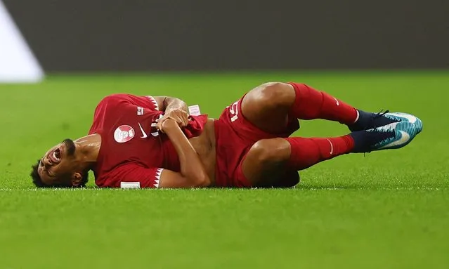 Qatar's defender #14 Homam Ahmed reacts after picking up an injury during the Qatar 2022 World Cup Group A football match between Qatar and Senegal at the Al-Thumama Stadium in Doha on November 25, 2022. (Photo by Kai Pfaffenbach/Reuters)