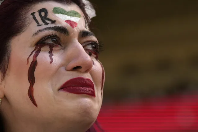 An Iranian woman, name not given, breaks into tears after a member of security seized her flag reading “Woman Life Freedom” before the start of the World Cup group B soccer match between Wales and Iran, at the Ahmad Bin Ali Stadium in Al Rayyan, Qatar, Friday, November 25, 2022. (Photo by Alessandra Tarantino/AP Photo)