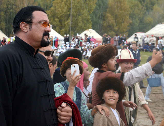 Hollywood actor Steven Seagal (L) and people in traditional dress in a specially built village setting, Kyrchin, at the 2016 World Nomad Games in Cholpon-Ata, Kyrgyzstan on September 4, 2016. (Photo by Viktor Drachev/TASS via Getty Images)