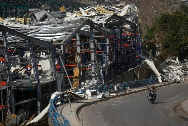 Men ride a motorcycle past the damage near the site of Tuesday's blast in Beirut's port area, Lebanon on August 7, 2020. (Photo by Hannah McKay/Reuters)