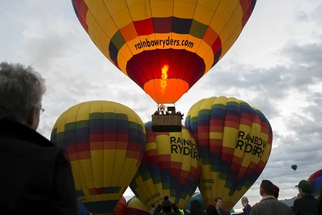 Attendees watch and take pictures as hundreds of hot air balloons lift off on the first day of the 2015 Albuquerque International Balloon Fiesta in Albuquerque, New Mexico, October 3, 2015. (Photo by Lucas Jackson/Reuters)