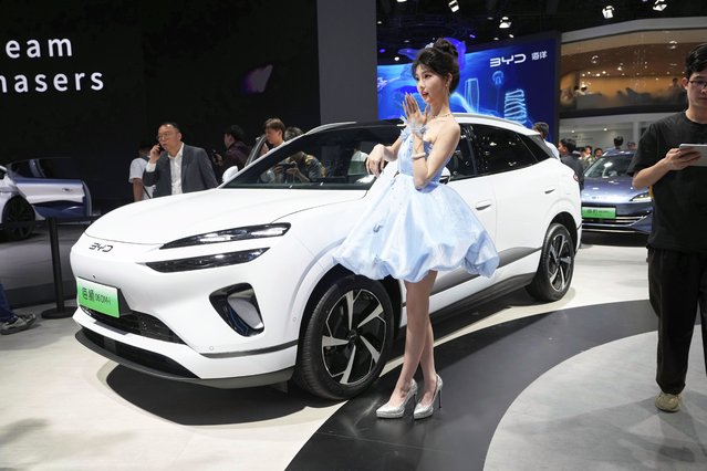 A model poses near the Sea Lion 06 DM-i model from BYD at the Shanghai auto show on Wednesday, April 23, 2025. (Photo by Ng Han Guan/AP Photo)