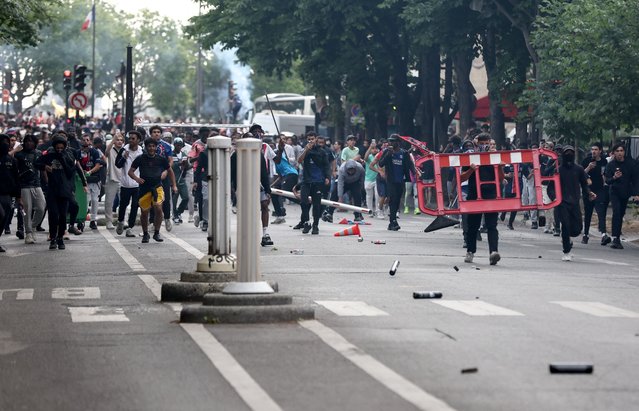 Crowd clash with police officers following the PSG team bus parade, near the Champs-Elysees avenue in Paris on June 1, 2025, a day after PSG won the 2025 UEFA Champions League final football match against Inter Milan in Munich. (Photo by Romain Perrocheau/AFP Photo)