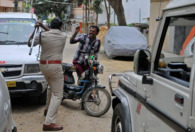 Police raises his baton at a man who defied a curfew in Bengaluru, following violent protests after India's Supreme Court ordered Karnataka state to release water from the Cauvery river to the neighbouring state of Tamil Nadu, India September 13, 2016. (Photo by Abhishek N. Chinnappa/Reuters)