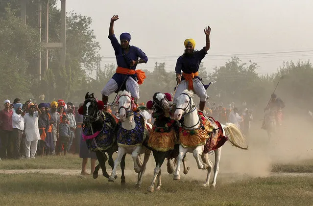 Nihangs or Sikh warriors, display their skills during a religious procession to mark the Bandi Chhorh Divas in Amritsar October 24, 2014. (Photo by Munish Sharma/Reuters)