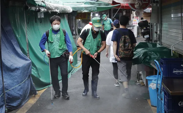 People disinfect as a precaution against the coronavirus at a local market in Seoul, South Korea, Wednesday, September 2, 2020. (Photo by Lee Jin-man/AP Photo)