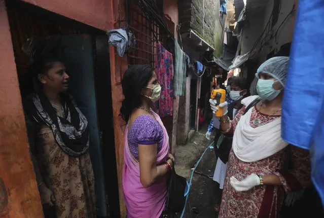 A health worker screens people for symptoms of COVID-19 in Dharavi, one of Asia's biggest slums, in Mumbai, India, Friday, September 4, 2020. The number of people infected with the coronavirus in India rose by another 80,000 and is near Brazil's total, the second-highest in the world. (Photo by Rafiq Maqbool/AP Photo)